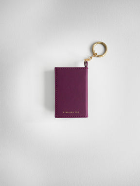 A burgundy leather card holder keychain with gold-tone hardware, featuring the brand name 'STERLING INK' debossed on the front, set against a light gray textured background.
#Color_Mulberry