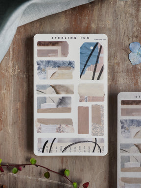 A sheet of September 2025 Torn Tape Stickers featuring aesthetic, distressed scrapbook paper with muted blue, gray, and cream abstract patterns and hand-lettered designs.