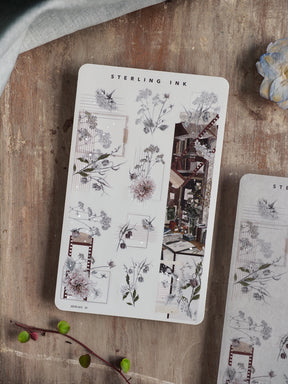Elegant botanical sticker sheet featuring black and gray line art of floral bouquets, wreaths, and washi tape borders with subtle silver foil accents.