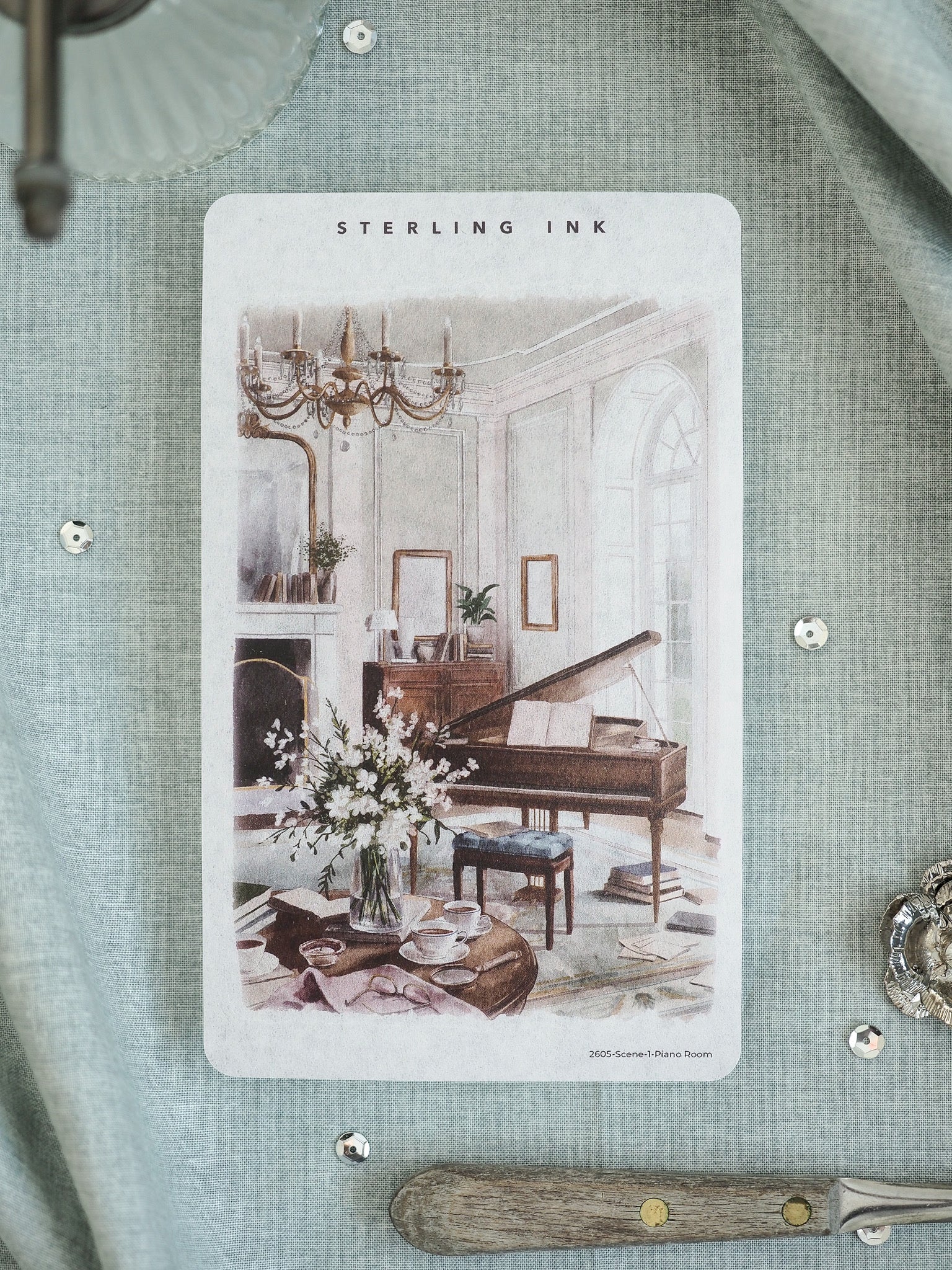 Sterling Ink illustration card depicting a romantic, classical parlor scene with a grand piano, chandelier, and elegant floral details.