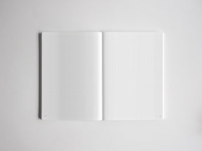 Open sketchbook featuring two pages of white graph paper with light gray grid lines, ideal for drawing, technical notes, or planning.
