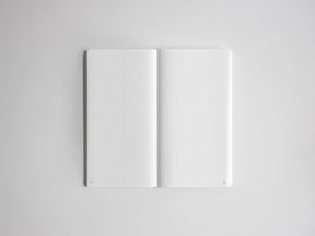 Open sketchbook displaying graph paper lines on two blank pages, perfect for technical drawing, planning, or academic note-taking.