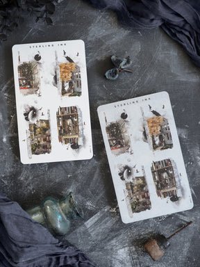 Autumn-themed collage stickers featuring delicate illustrations of historic European buildings, scattered foliage, and accents of reflective silver foil.