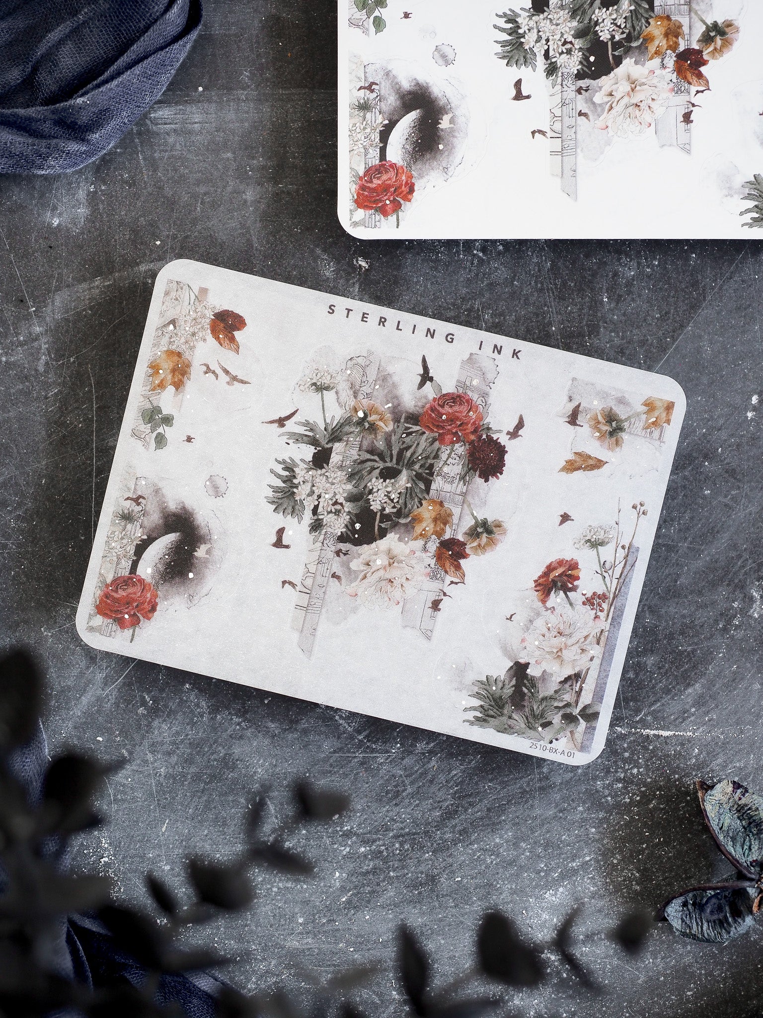 Vintage botanical sticker featuring "Sterling Ink" branding and a lush, detailed collage of red roses, assorted greenery, and small illustrated birds.
