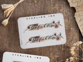 Rustic October month sticker featuring delicate botanical wreaths and berries framing the script text, perfect for autumnal journaling and planning.
