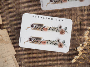 White label sticker featuring the script word "October" surrounded by rustic, deep-toned watercolor floral and botanical illustrations for autumn planning.