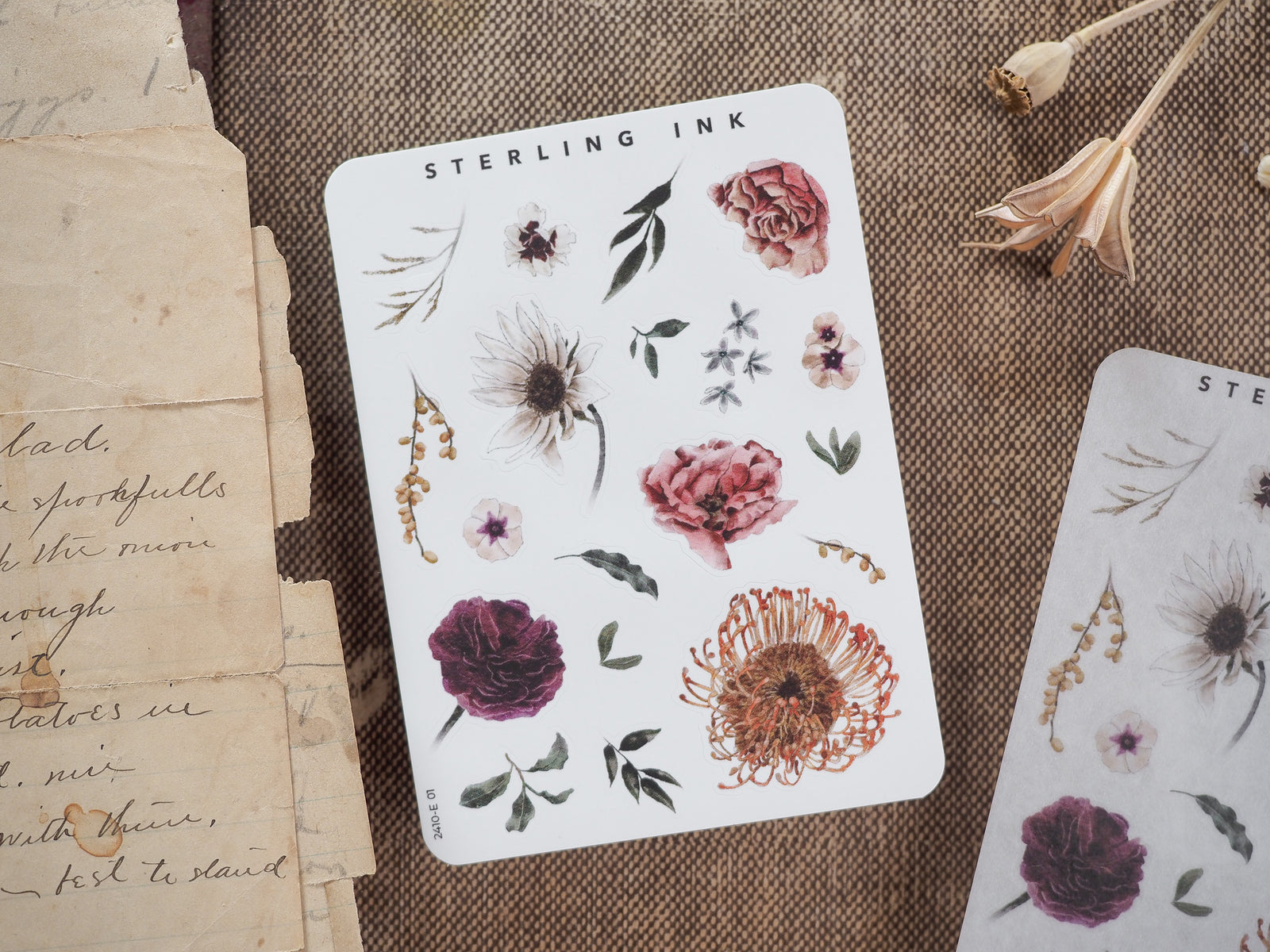 Botanical sticker sheet titled "STERLING INK," showcasing autumnal elements like deep red roses, assorted seasonal daisies, leaves, and rustic floral sprigs for crafting.