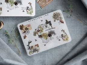Botanical-themed sticker collage featuring distressed vintage stamps, archival ink splatters, and delicate pressed flora for scrapbooking.