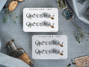 Rustic monthly planner stickers with "October" text, beautifully framed by muted watercolor botanical elements and delicate autumnal foliage.