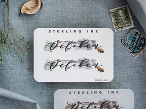 Elegant autumn-themed October calligraphy sticker featuring muted watercolor accents and a sophisticated design for journaling and scrapbooking.