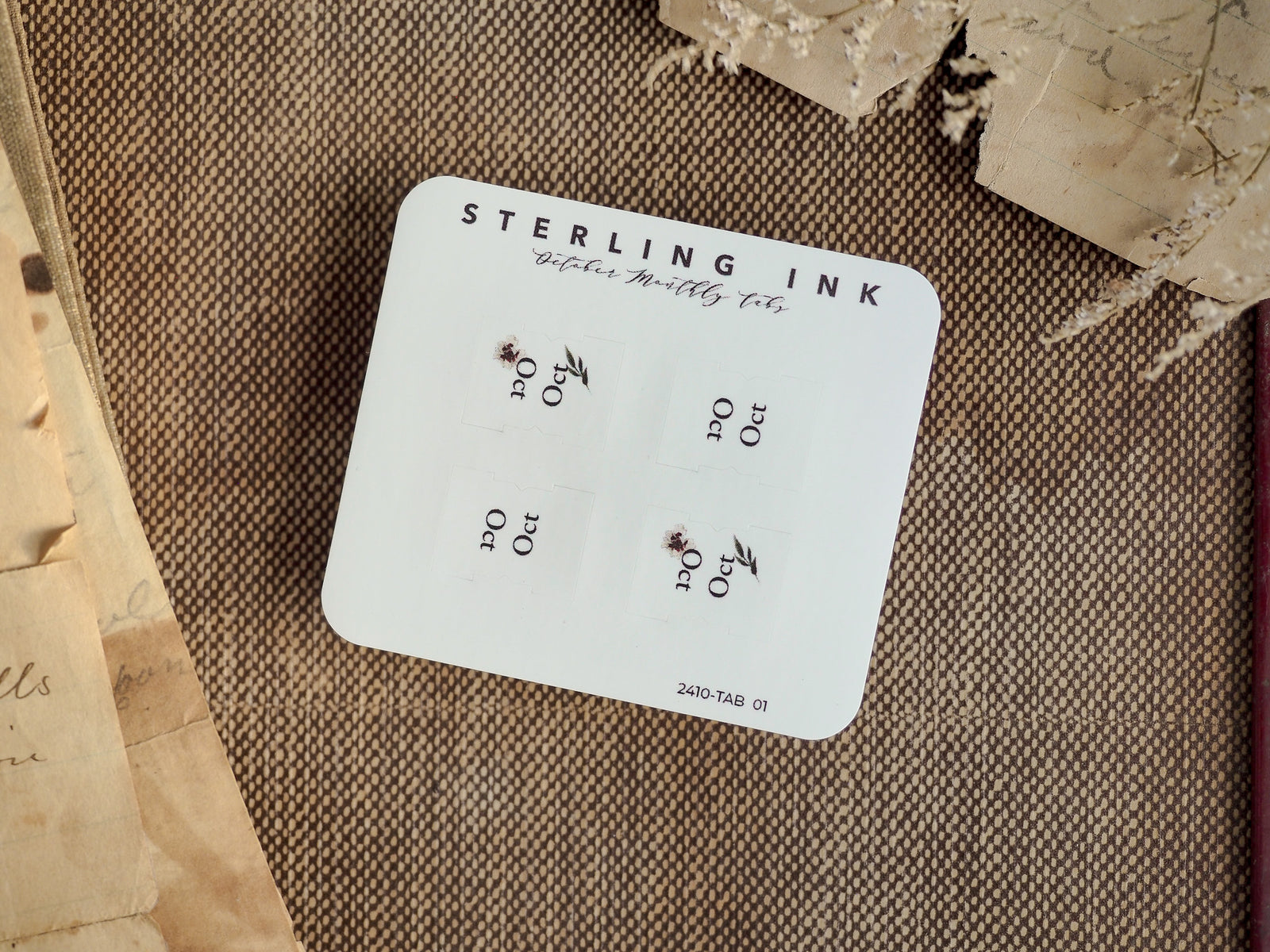 A white planner tab set for October 2024 by Sterling Ink, featuring neatly aligned decorative corner tabs for organizing journal entries.