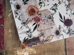 Autumn-themed monthly calendar page with intricate botanical illustrations featuring deep-toned roses, dahlias, and rich autumnal foliage on cream vellum paper.