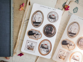 Collection of vintage sepia picture frame stickers, perfect for journaling, featuring various oval and rectangular frames showcasing cozy architectural scenes.