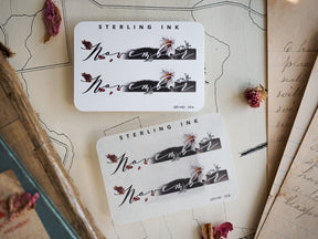 Elegant November month sticker featuring dark script lettering and delicate autumnal botanical accents of berries and foliage.