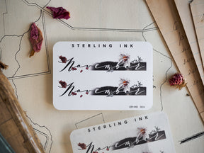 Elegant white "November" month sticker featuring graceful script lettering and delicate autumnal floral and leaf embellishments for planners.