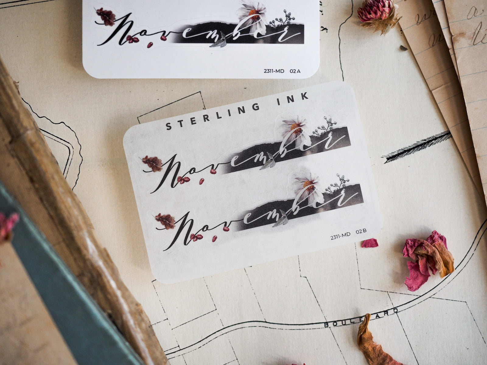 Black and gray ink sticker set for November, featuring elegant scripted calligraphy and delicate pressed floral illustrations suitable for journaling and planning.