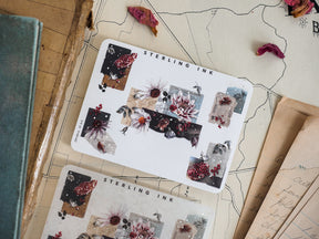 Botanical sticker sheet featuring rustic designs of dried flowers, deep reds and creams, elegant corner accents, and detailed silver foil elements.