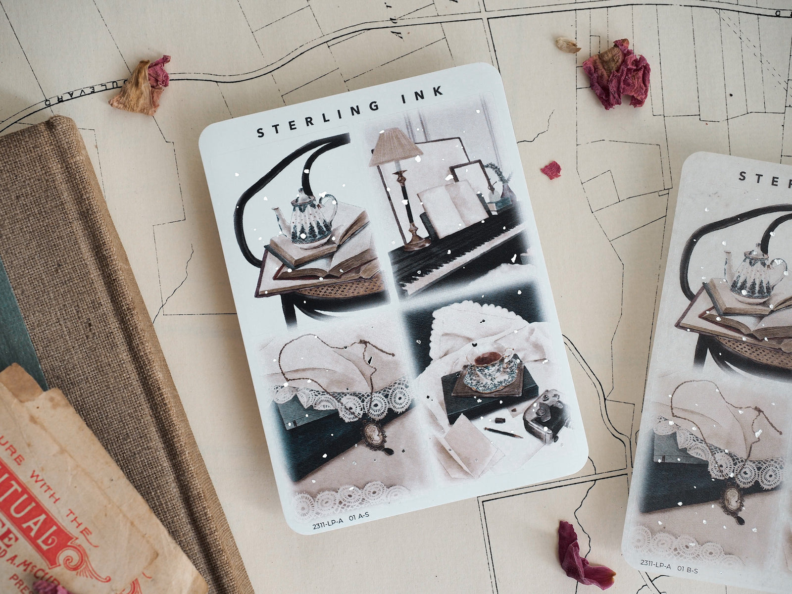 Large sticker sheet with vintage black and white illustrations, featuring elegant still life scenes and accouterments of sparkling silver foil.