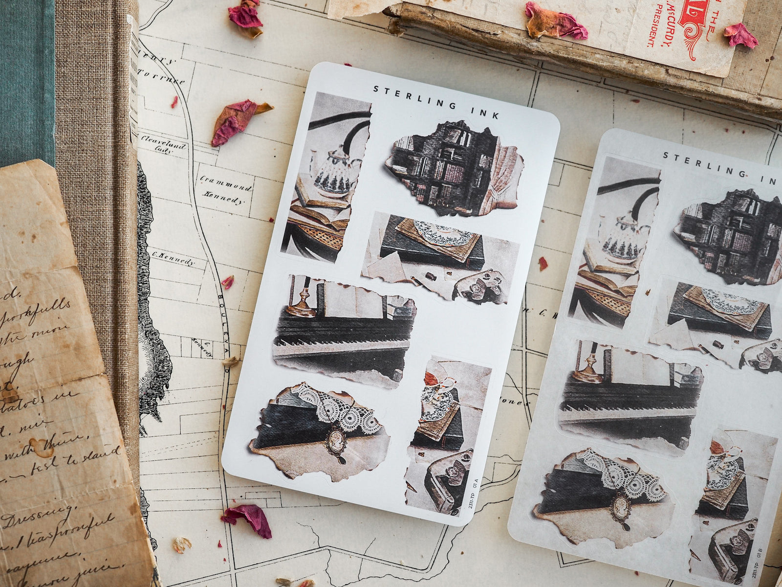 Sheets of decorative, black and white 'Sterling Ink' torn stickers, featuring vintage illustrations of borders, scrolls, and literary ephemera for journaling.