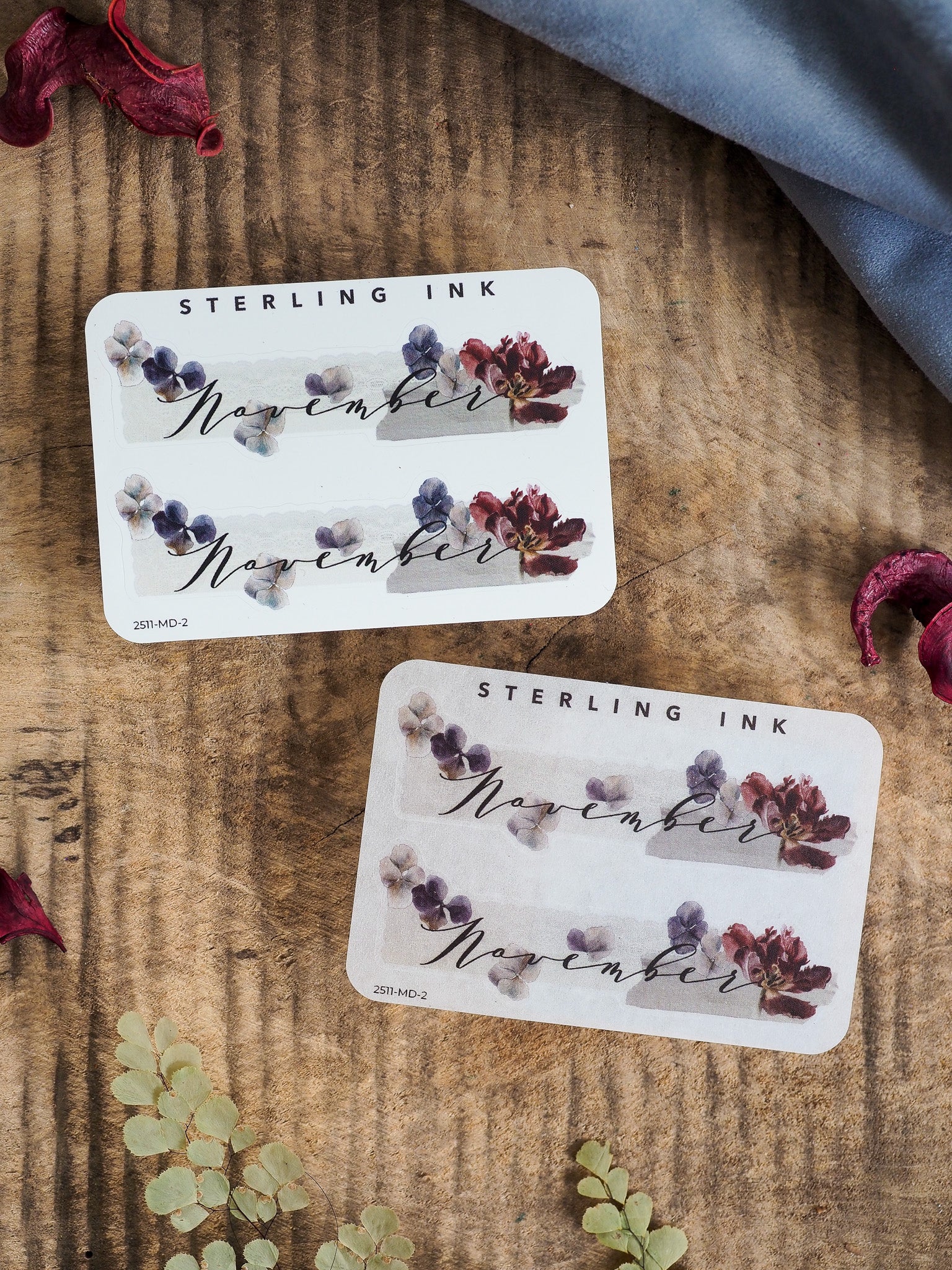 Planner sticker for November featuring "STERLING INK" text and a delicate arrangement of pressed, rustic floral bouquets in deep purple and burgundy hues.