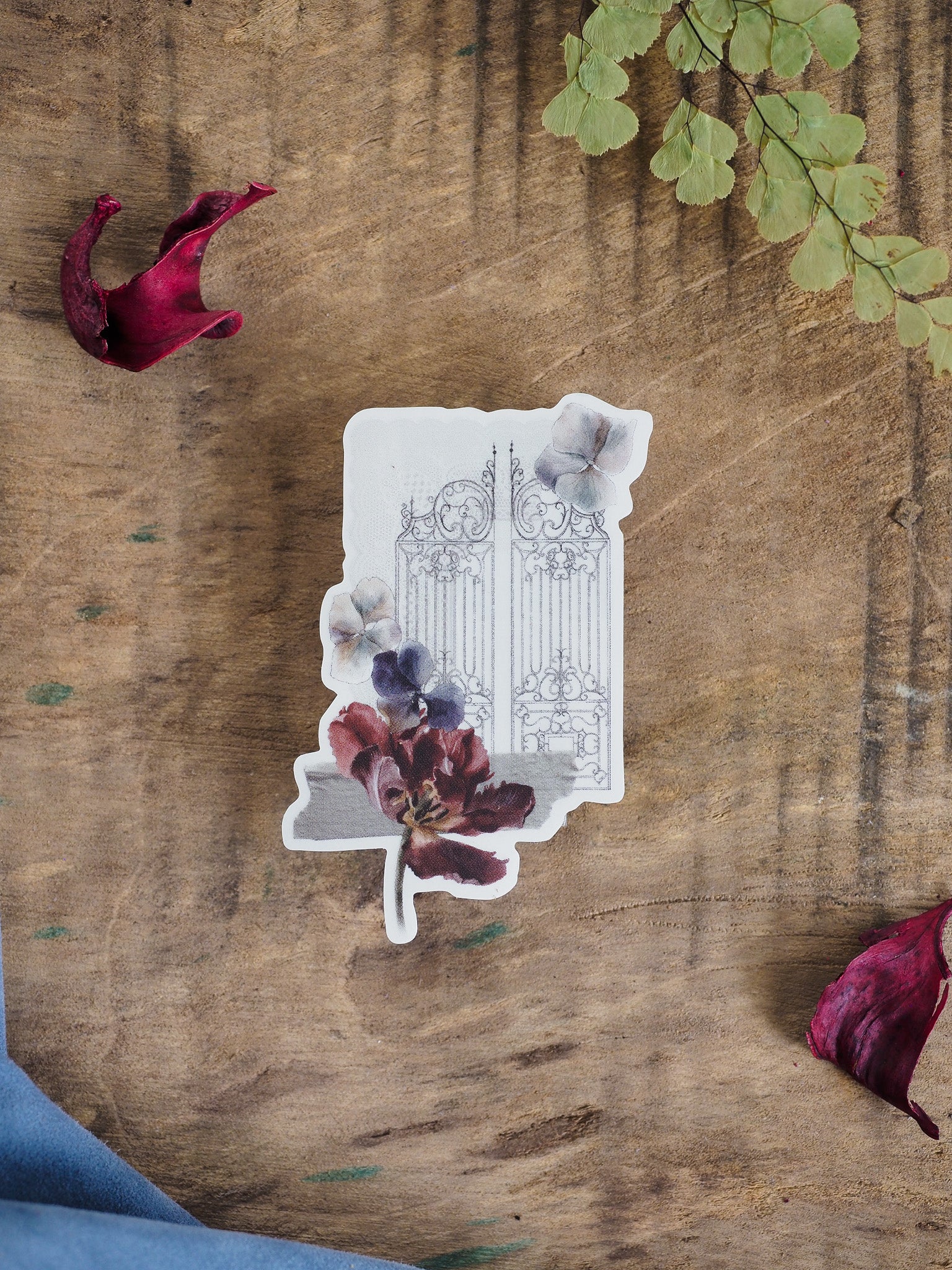 Elegant die-cut sticker combining a vintage ornate gate pattern with rich watercolor florals in muted tones of burgundy and blue.