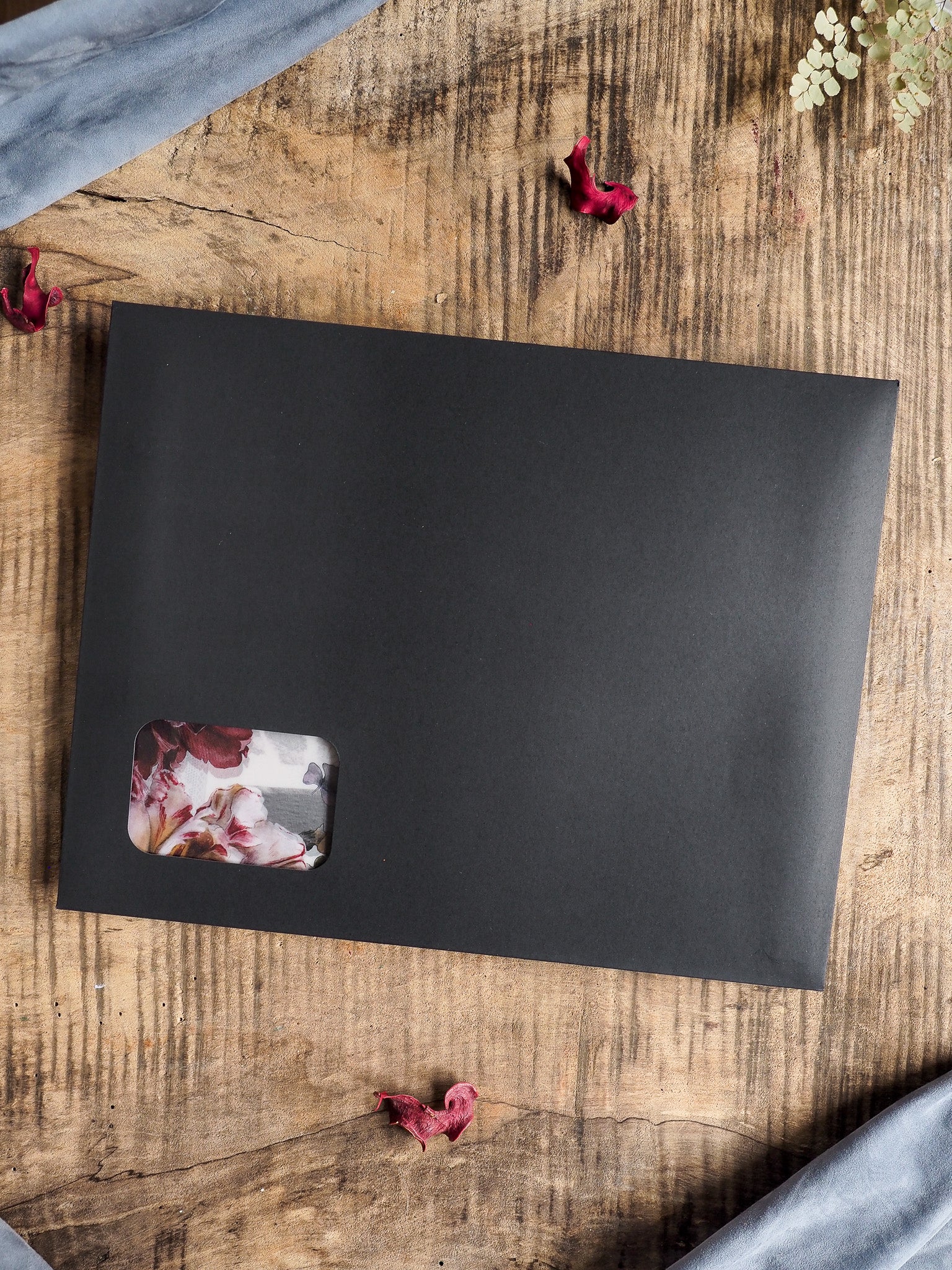 Large matte black planner or journal with a cream-toned accent sticker showcasing muted, autumnal watercolor florals, ready for November planning.