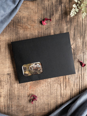 Minimalist matte black stationery card featuring a central, distressed rectangular sepia photograph, perfect for limited edition subscription kits.