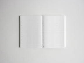 Open spiral notebook displaying two clean pages of white graph paper, featuring visible grid lines for drawing, studying, or professional note-taking.