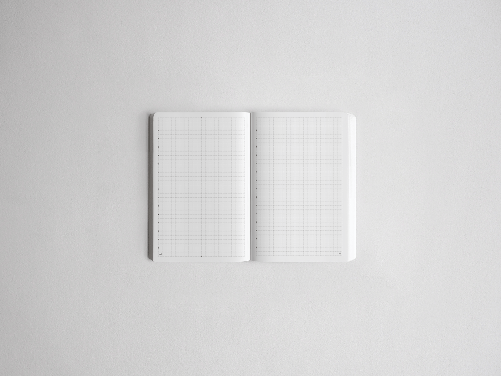 Open notebook featuring blank, white gridded pages, perfect for studying, planning, drawing, or bullet journaling.