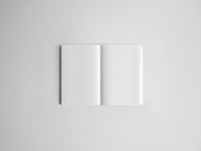 Open notebook featuring blank, white gridded pages, perfect for studying, planning, drawing, or bullet journaling.