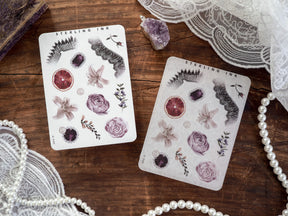 Botanical sticker sheets for November 2024, featuring delicate watercolor illustrations of blush roses, citrus slices, and dark stylized nature elements from the Elements collection.