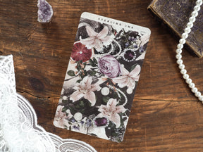 Moody floral deco sheet featuring delicate white blossoms and dramatic deep plum roses surrounded by lush green foliage and dark accents.