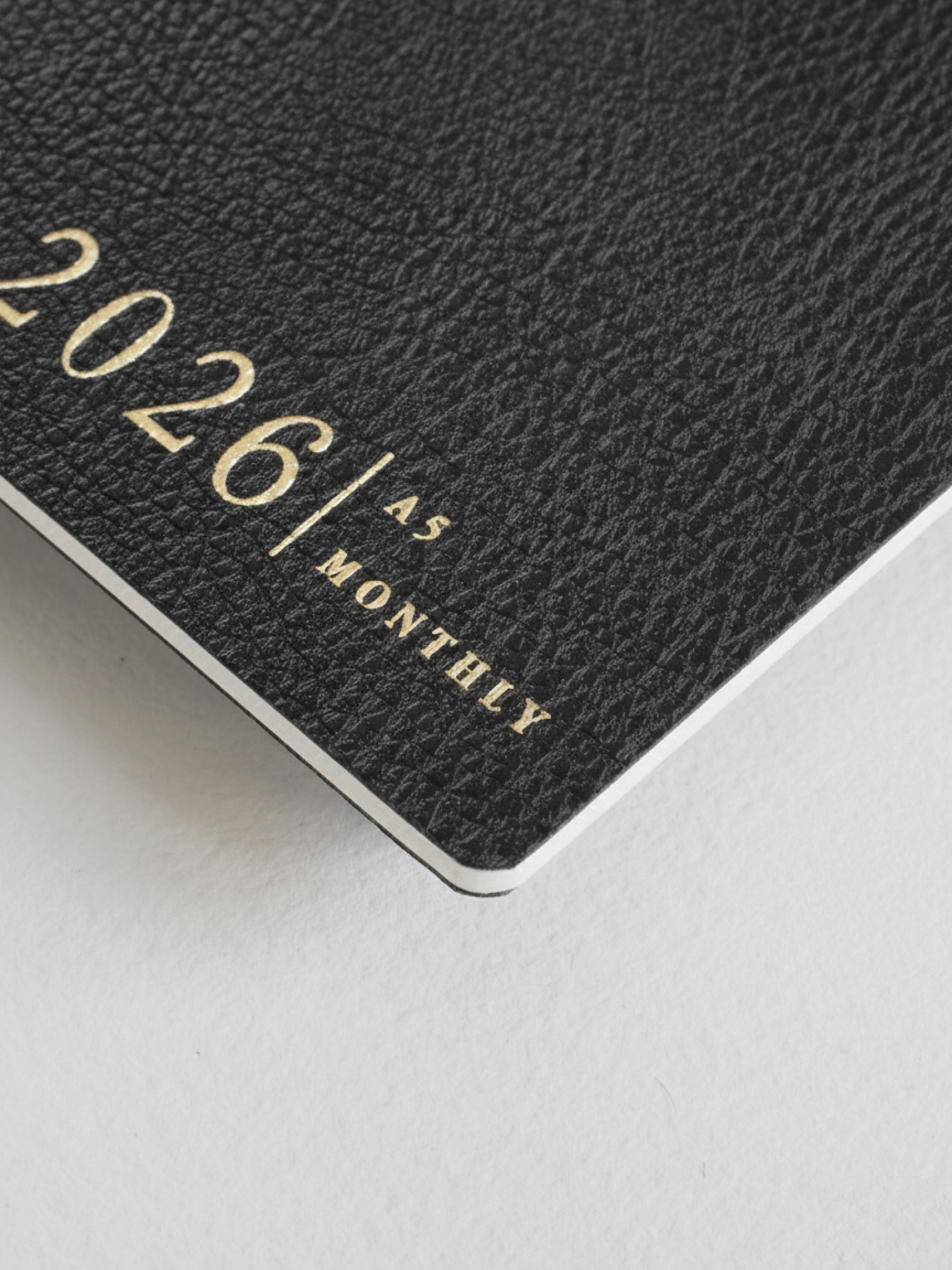 Dark gray A5 monthly booklet cover featuring the title "2026 A5 MONTHLY" printed in elegant, contrasting gold lettering.