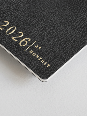 Dark gray A5 monthly booklet cover featuring the title "2026 A5 MONTHLY" printed in elegant, contrasting gold lettering.