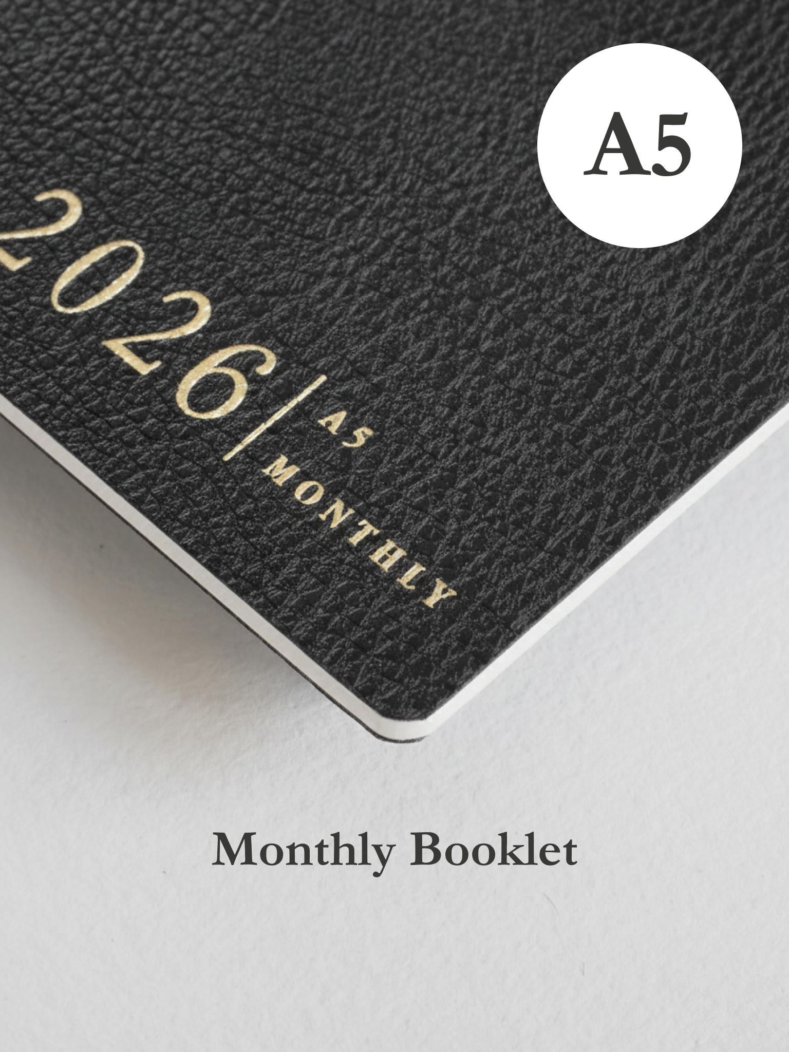 Dark grey A5 monthly planner cover featuring embossed text reading "2026" and "MONTHLY," perfect for yearly organization and planning.