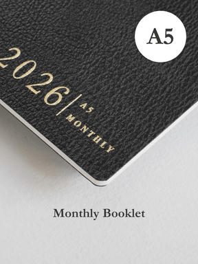 Dark grey A5 monthly planner cover featuring embossed text reading "2026" and "MONTHLY," perfect for yearly organization and planning.