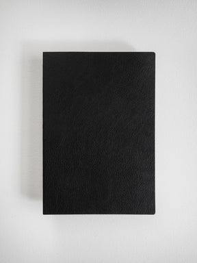 Solid black A5 notebook featuring a smooth, deep-textured faux leather cover, ideal for grid planning or journaling.