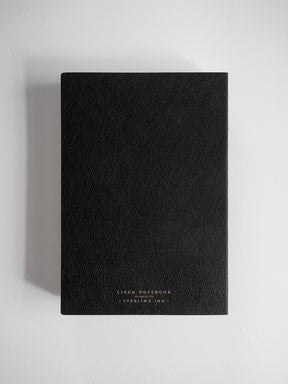 Minimalist black A5 lined notebook with a textured, deep black cover, featuring centered, embossed lettering that reads "LINED NOTEBOOK" and "STERLING INK."
