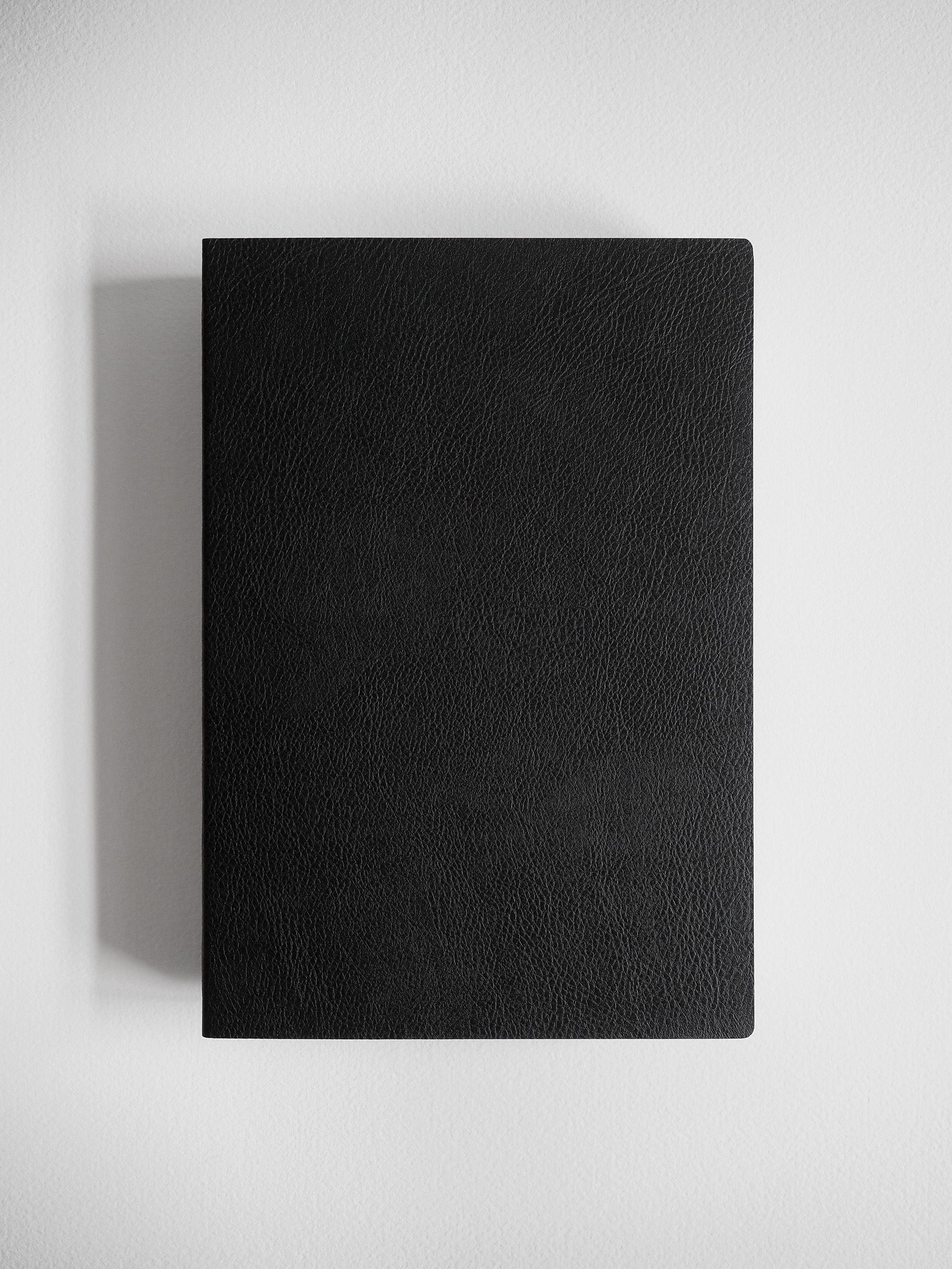 Minimalist A5 notebook featuring a solid, matte black cover with a subtly textured, uniform finish for writing and journaling.