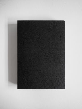 Minimalist A5 notebook featuring a solid, matte black cover with a subtly textured, uniform finish for writing and journaling.