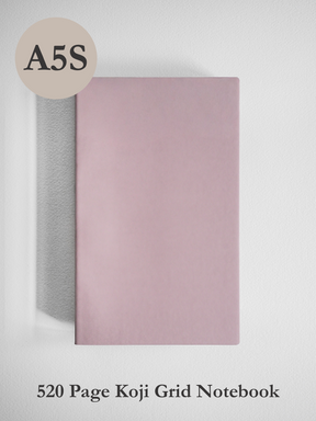 Stylish A5 slim notebook with a solid pale blush pink cover, featuring 520 pages of grid paper and premium Koji paper for writing.