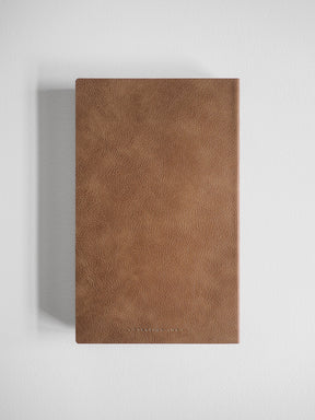 A slim A5 grid notebook featuring a richly textured, warm cocoa-brown faux-leather cover, perfect for extensive journaling and studies.