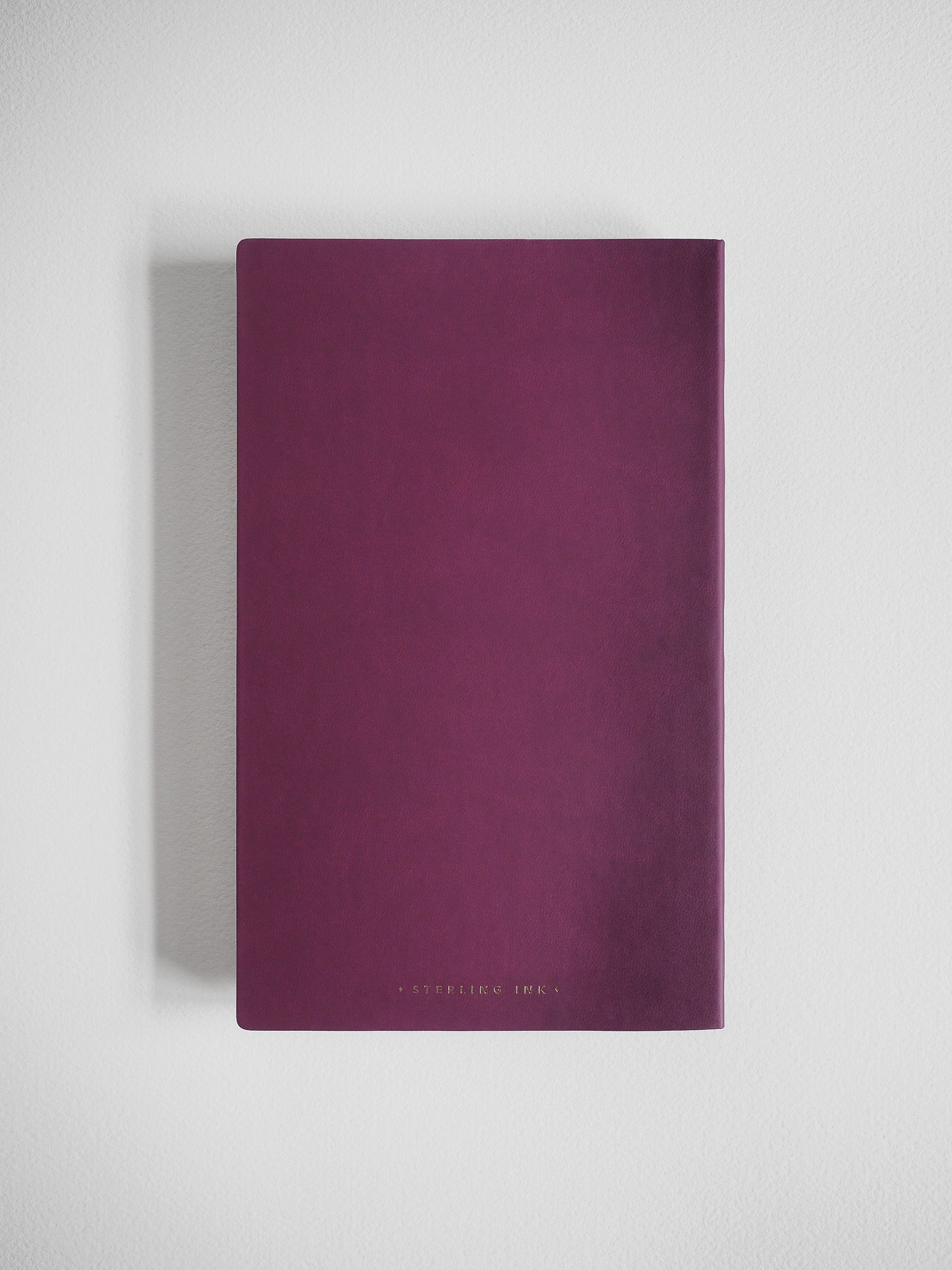 Solid, deep plum A5 grid notebook featuring a minimalist, matte cover ideal for journaling or daily planning.