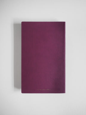 Solid, deep plum A5 grid notebook featuring a minimalist, matte cover ideal for journaling or daily planning.