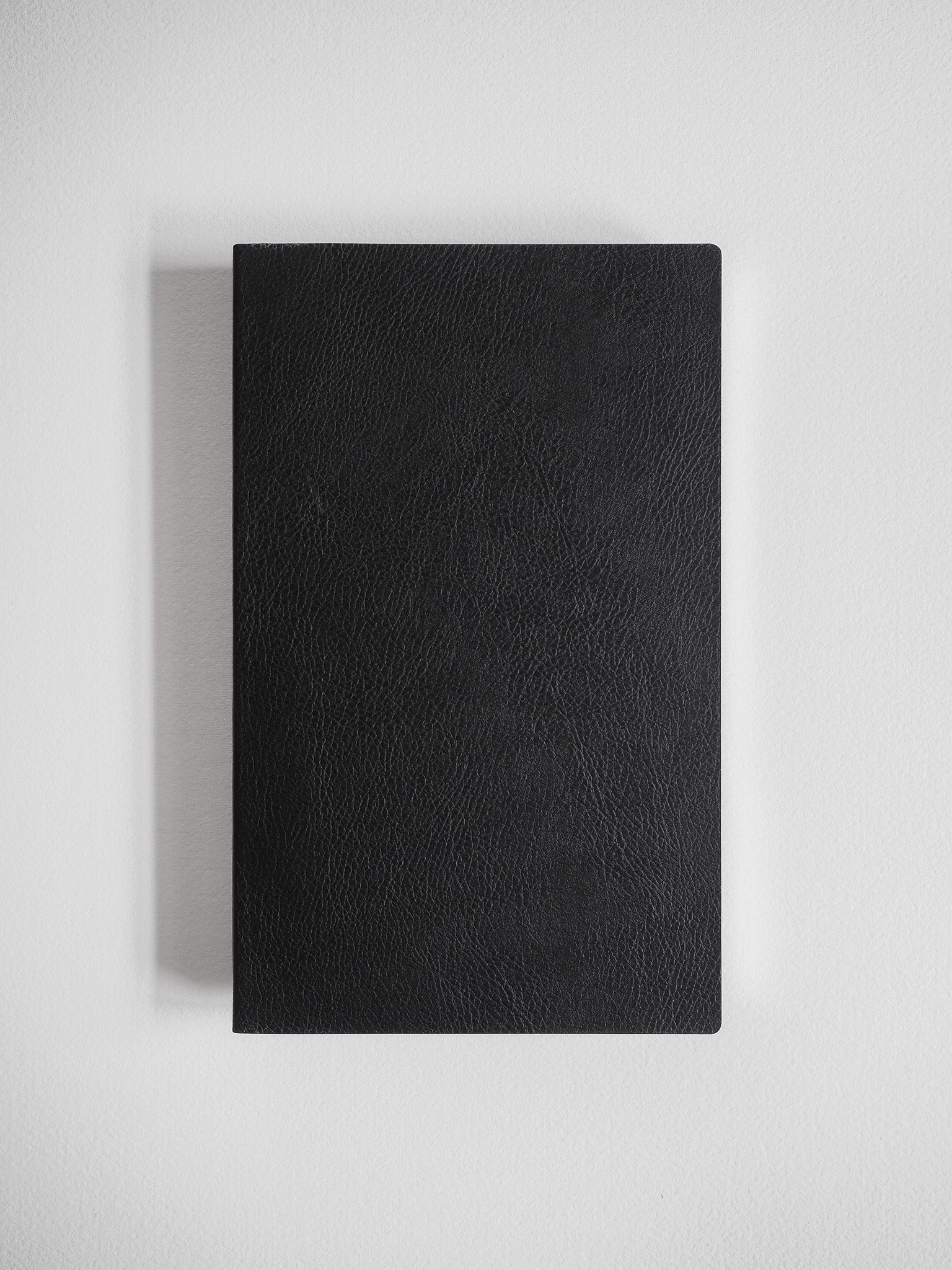 Sleek A5 notebook featuring a solid black, subtly textured cover, ideal for journaling or study notes.