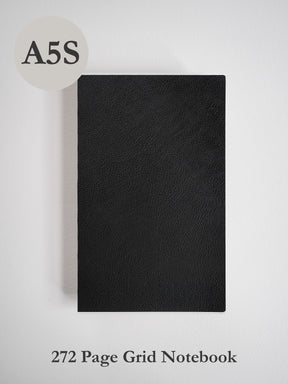 Sleek, A5-sized notebook featuring a solid matte black faux-leather cover, ready for detailed note-taking with 272 internal grid pages.
