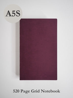 Solid A5 grid notebook featuring a sleek, uniform deep burgundy cover, ideal for journaling and academic note-taking.