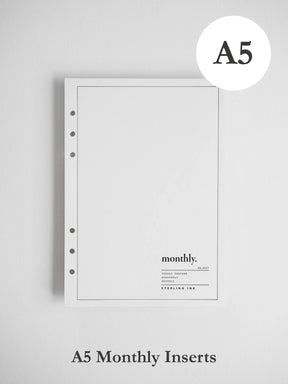 A white A5 monthly insert notebook page with a thin border, five binder holes on the left, and the word 'monthly.' printed near the bottom, shown on a light gray background.
#Size_A5