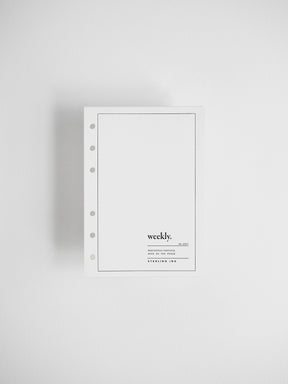 A minimalist white weekly planner insert with a five-hole punch on the left side, featuring the text 'weekly.' and 'STERLING INK' printed in black on the lower right, set against a clean white background.
#Size_A6