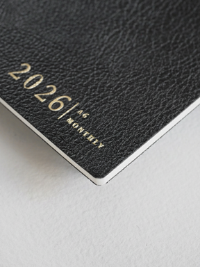 Elegant dark gray A6 monthly planner cover for 2026, featuring minimalist silver lettering that clearly displays "2026 | A6 | MONTHLY."